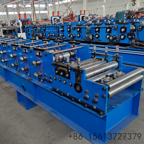 M&aacute;quina de fabrica&ccedil;&atilde;o de ter&ccedil;as e montantes com cabe&ccedil;ote de corte hidr&aacute;ulico duplo vis&iacute;vel no topo, especializada na produ&ccedil;&atilde;o de componentes para estruturas de galp&otilde;es industriais.