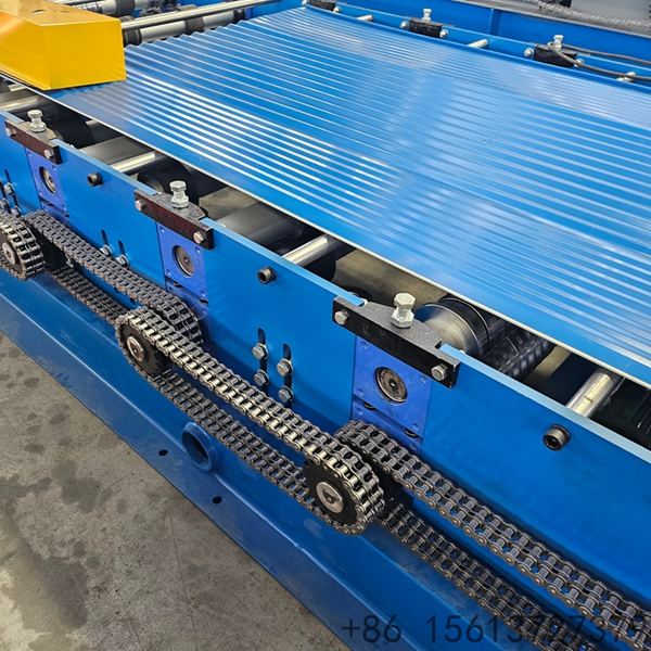 Factory floor scene with a yellow safety line separating the walkway from the corrugated sheet equipment.