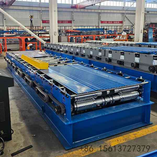 Industrial corrugated roof sheet roll forming machine processing steel coils in a factory.