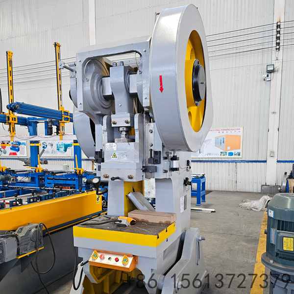 Front view of industrial mechanical power press with large yellow flywheel and C-frame structure for metal stamping.