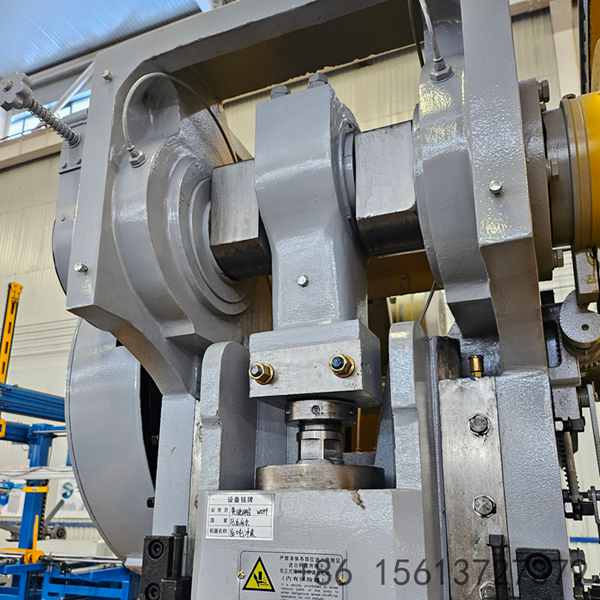 Side angle of the mechanical press showing the robust cast iron frame and flywheel design for stable energy transmission.