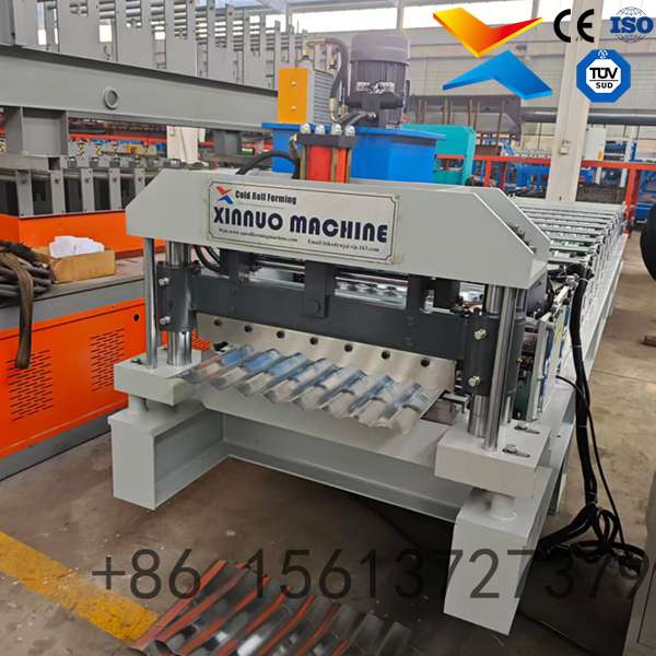 Industrial corrugated roof sheet roll forming machine processing color steel coils into metal roofing panels in a factory.