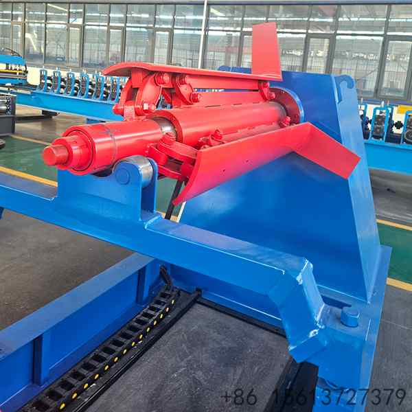 Fully loaded hydraulic uncoiler processing a heavy galvanized steel coil in an industrial workshop