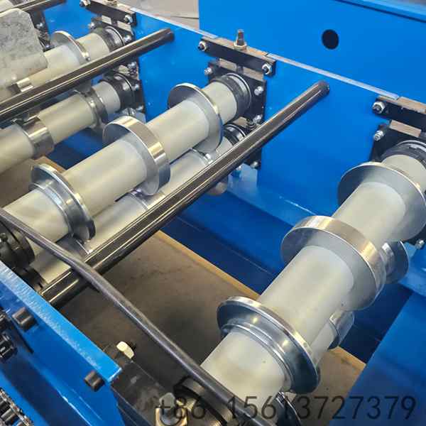 Forming stations of the exterior wall cladding machine folding a metal cladding panel for a building facade